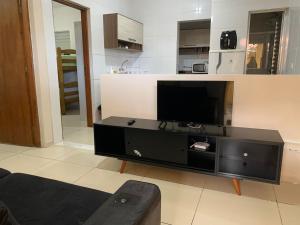 uma sala de estar com um centro de entretenimento preto com uma televisão de ecrã plano em Apartamento próximo ao Autódromo de Interlagos em São Paulo