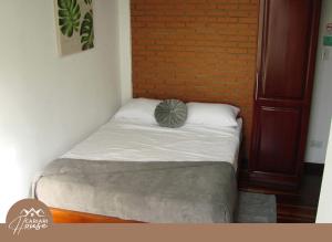 a small bed in a room with a brick wall at Full house, 11BR, 12BA, 10 min from SJO Airport in Heredia