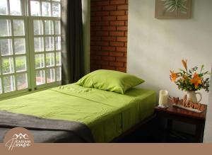a bedroom with a green bed and a window at Full house, 11BR, 12BA, 10 min from SJO Airport in Heredia