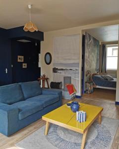 a living room with a blue couch and a coffee table at Bulle marine paisible proche de la gare et du port in Brest