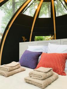 ein Bett mit drei Kissen und Handtüchern darauf in der Unterkunft Ô cocon del Lauragués & spa in Ricaud