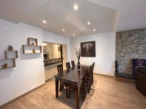 ein Esszimmer mit Tisch und Stühlen und einem Kamin in der Unterkunft Appartement centre-ville très spacieux avec 4 chambres in La Tour-du-Pin