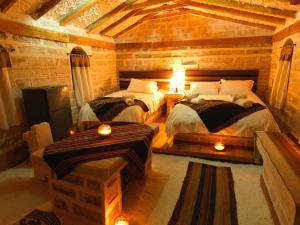 a room with two beds in a wooden room with lights at Tambo Coquesa Lodge in Coquesa +3 photos