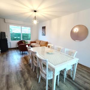 ein Esszimmer und ein Wohnzimmer mit Tisch und Stühlen in der Unterkunft La maison d'à côté in Montreuil-sur-Mer