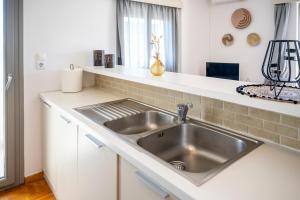 a kitchen with a stainless steel sink and a counter at City Calm House in Platánion +79 photos