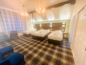 a hotel room with three beds and a chair at Hylands Hotel in Coventry