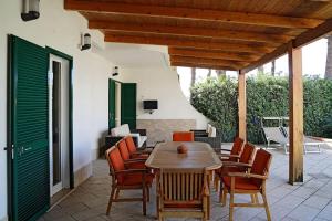 a wooden table and chairs on a patio at Villa Belvedere - Baia azzurra in Torre San Limato