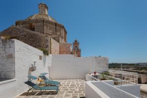 a view from the rooftop of a building with blue chairs at Dimora Lavinia Casa vacanze Centro storico Ostuni in Ostuni