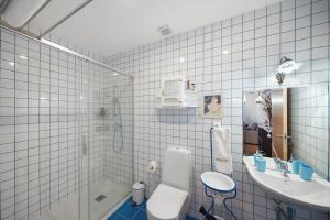 a white tiled bathroom with a toilet and a sink at Casa da Edrosa in Edrosa +26 photos