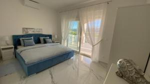 a bedroom with a blue bed and a large window at Casa Blanca in Pag +169 photos