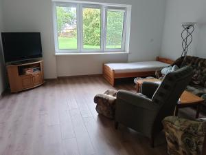 a living room with a couch and a tv at Agroturystyka Słupeczka in Okoleniec