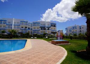 a swimming pool in front of a large building at Riviera Beach Cabonegro in Cabo Negro