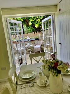 a table with plates and flowers on top of it at Tythe Barn Cottage in Glastonbury +31 photos