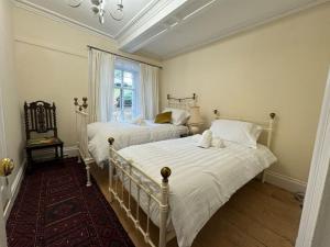 ein Schlafzimmer mit zwei Betten und einem Fenster in der Unterkunft Cae Nest Hall in Llanbedr