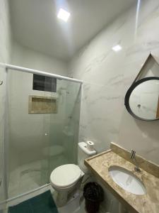 un bagno con un water, un lavandino e uno specchio di Casa da Praia Carapibus a Conde