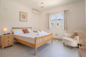 a bedroom with a bed and a chair and a window at Casa Angilaga in Jávea +23 photos