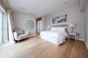 a white bedroom with a bed and a chair at Aviva Stadium Mews Dublin - #avivamews in Dublin
