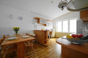 a kitchen and dining room with a wooden table and a dining room at Wileńska Pokoje in Słupsk