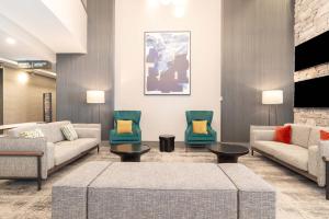 多倫多的住宿－多倫多機場桑德曼簽名酒店，大堂配有沙发、椅子和电视。
