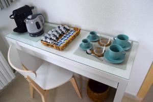 a white table with a tray of food and cups and coffee at 12 Passi dal Mare in Bari