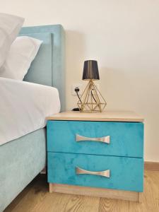 a blue dresser next to a bed with a blue drawer at Olea Apartment in Igoumenitsa