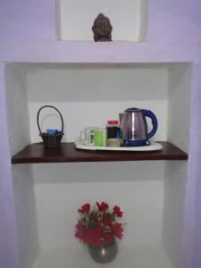 a shelf with a tea pot and a flower on it at Feel Aesthetic Kashi Home Stay in Varanasi