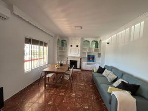 a living room with a blue couch and a table at Casa Rural Alora Caminito del Rey in Alora