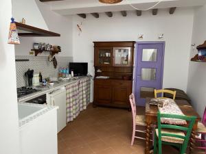 a kitchen with a table and a purple door at Casa Civetta in Stromboli