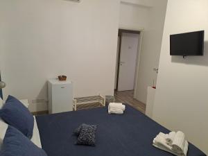 een woonkamer met een blauw bed met handdoeken erop bij Bedroom la stazione in Palermo