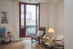 sala de estar con silla, mesa y ventana en SingularStays Plaza Redonda, en Valencia