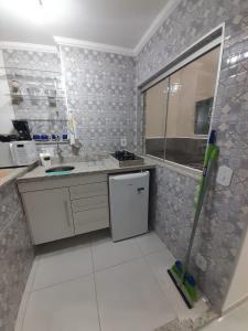 a kitchen with a sink and a stove at Apartamento Aconchegante in São Lourenço