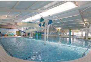 an indoor swimming pool with a water slide at Lifes a Beach on Presthaven Sands in Prestatyn +17 photos