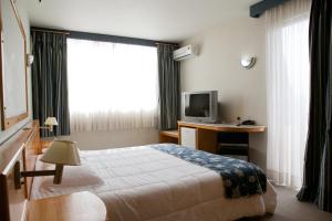 A bed or beds in a room at Atalaia Palace Hotel