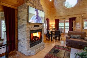 a living room with a stone fireplace with a tv at Belvedere by Eden Crest in Sevierville