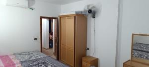 a bedroom with a bed and a dresser and a fan at قرية بالميرا للعائلات فقط in Ain Sokhna +65 photos