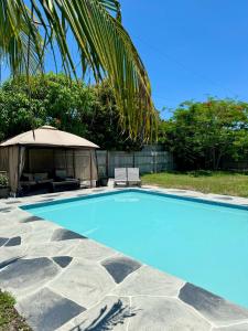 a swimming pool with an umbrella and a table and chairs at Casa La Paz in Lantana