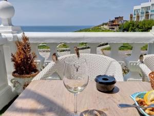 a table with a wine glass on a balcony at Pension Angelines, Sneuu Hostel Santander in Santander