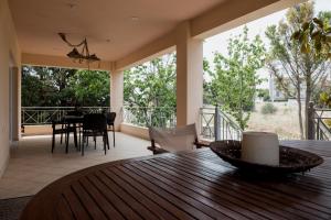 a living room with a wooden table and a balcony at Villa Discover Evia - With Private Jacuzzi in Aliveri