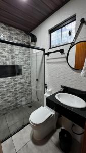 a bathroom with a toilet and a sink and a shower at Pousada Canto do Cedro in Lençóis