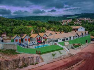 伦索伊斯Pousada Canto do Cedro的带游泳池的绿色屋顶房屋