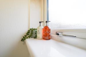 リビングストンにあるLivingston 4 Bed + Car Spaceの窓辺に置かれた石鹸2本と植物 +11枚の写真