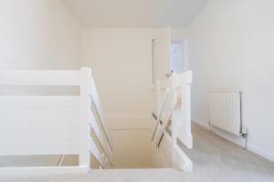 リビングストンにあるLivingston 4 Bed + Car Spaceの白い部屋(ベッド1台、階段付)