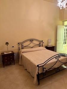 a bedroom with a bed and two tables and a chandelier at MAISON del MARE TERMOLI CB in Termoli