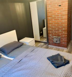 a bedroom with a bed and a brick wall at Pelēkzirņa Apartamenti in Ainaži