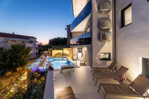 patio z basenem i krzesłami w obiekcie Villa Aurea Apartments Malinska de luxe w mieście Malinska