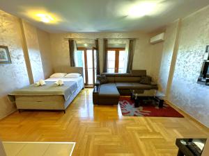 a living room with a bed and a couch at Renta Stanovi Podgorica in Podgorica