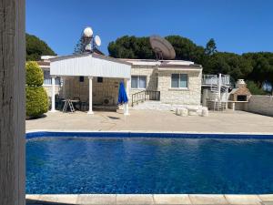 a house with a swimming pool in front of a house at villa 58 coral bay seafront in Peyia