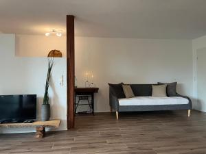 a living room with a couch and a tv at Apartment Kastanienblick in Tettnang