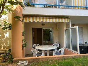 Appartement cosy piscine plage 2 pièces في فريجوس: فناء على طاولة وكراسي على شرفة +9 صور