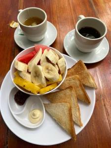 a plate with a bowl of toast and a cup of coffee at Santuario Getsemani Hostel in Cartagena de Indias +52 photos